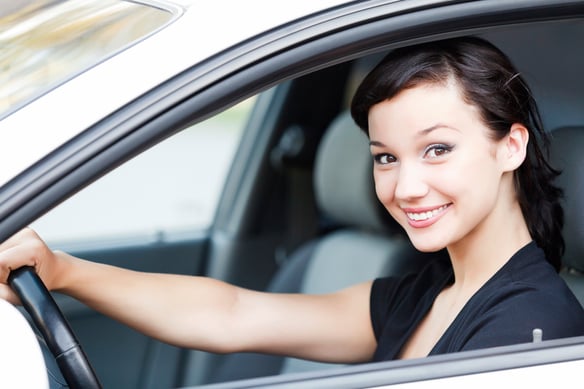 young woman with dark hair driving silver car